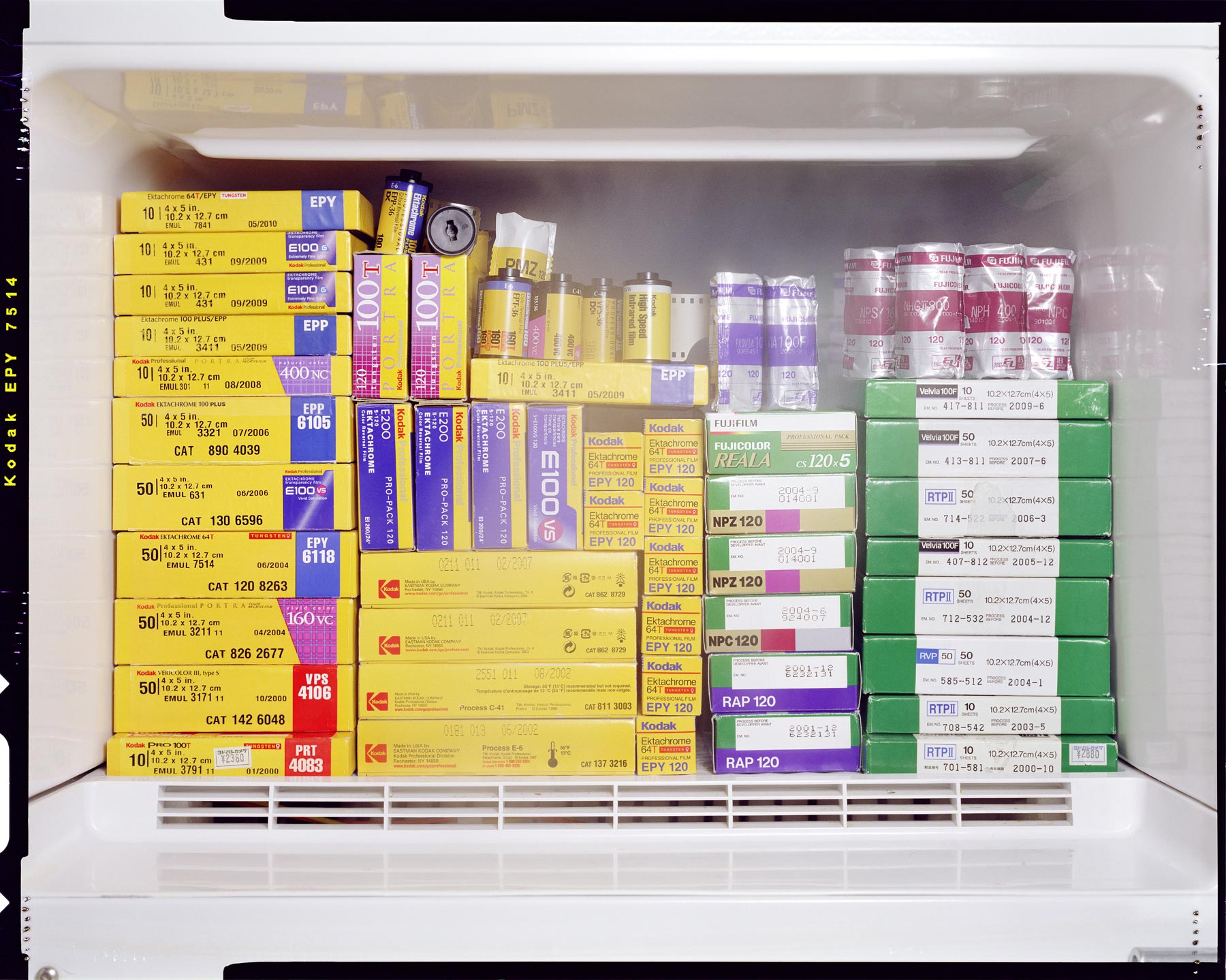 Conceptual photograph of an opened kitchen freezer filled with stacked large, medium and 35mm film.